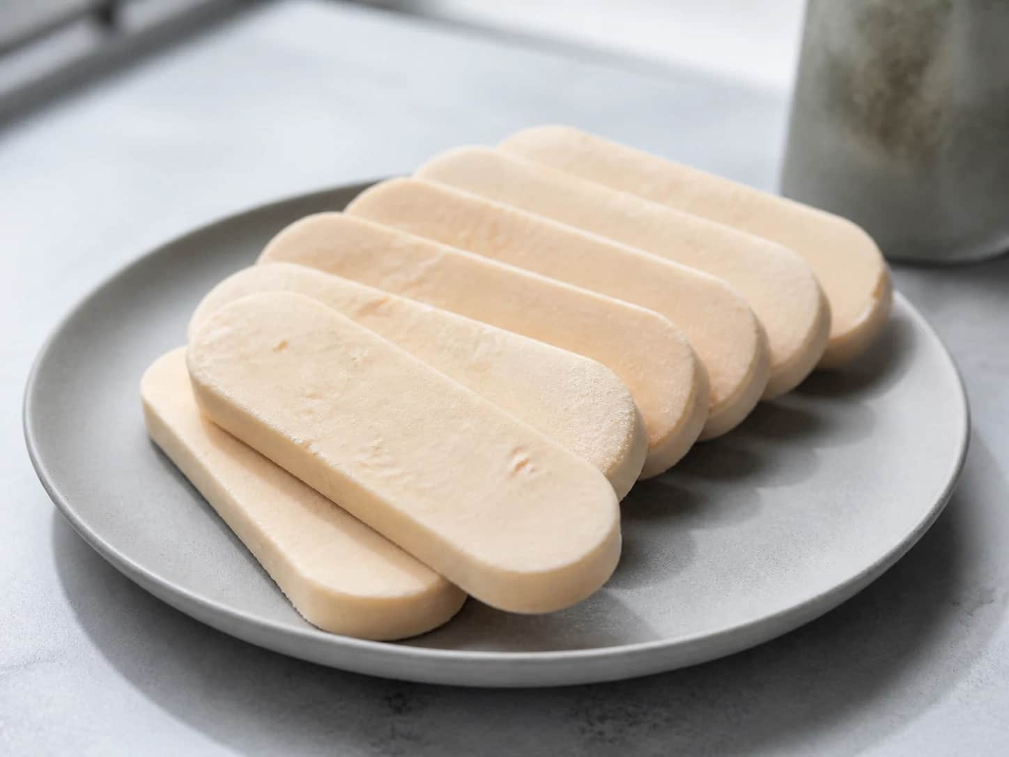 Slim creamy brown rice and goat milk frozen bars on a grey stoneware plate